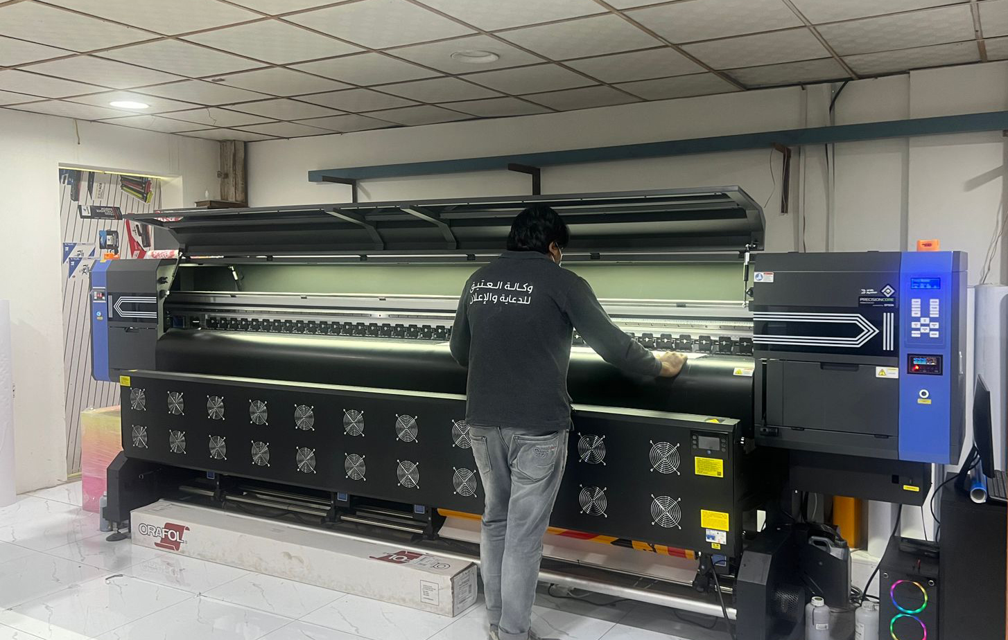 Professional large format printer producing high-quality colorful marketing materials in print shop