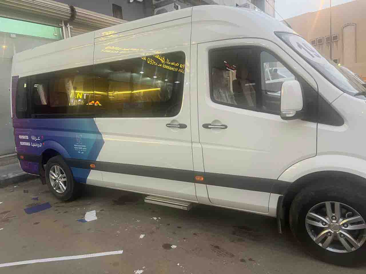 White delivery van with vibrant full-color brand wrap graphics parked on city street